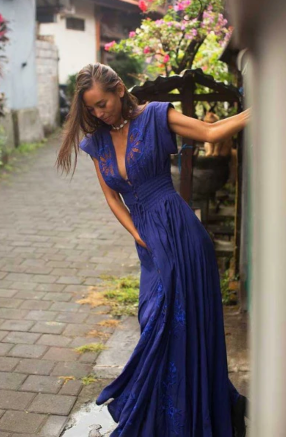 A woman in a blue dress on a cobblestone street