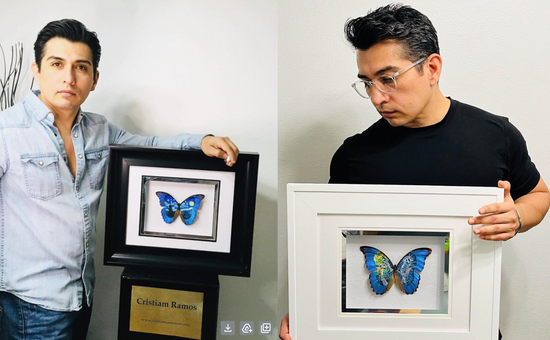 Christiam Ramos holding a framed butterfly with paint on its wings