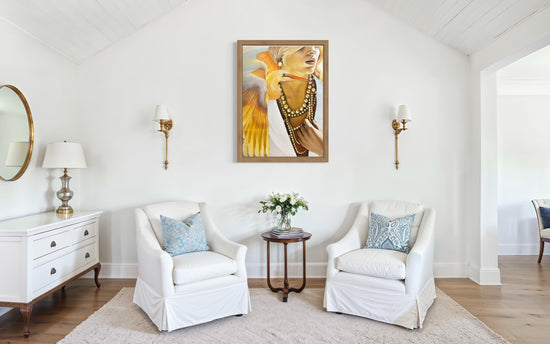 Art hanging in a white room with two chairs and lamps on the wall